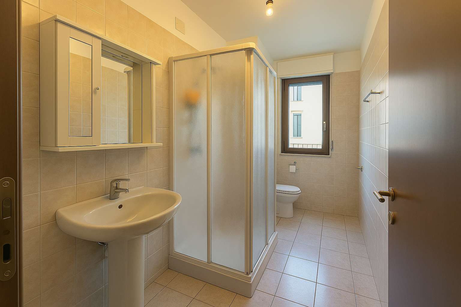 Badezimmer mit Waschbecken, Spiegelschrank und Duschkabine