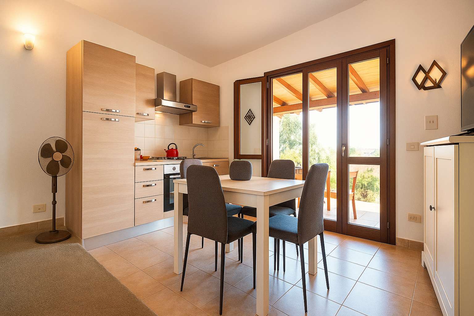 Cucina e zona pranzo con tavolo, sedie e porta-finestra sul portico